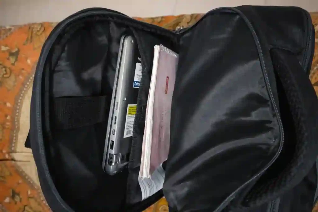 Inside view of Safari Omega Spacious 30L backpack packed with 15.6 inch laptop, notebooks, bottle, and headphones